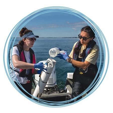 两个海洋科学专业的学生正在往一个采样容器里装海水